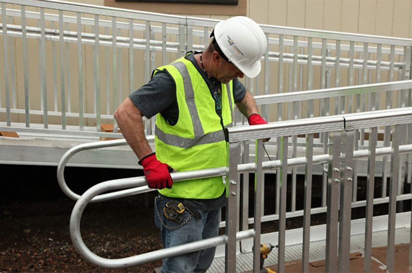 Man installing handrail on wheelchair ramp