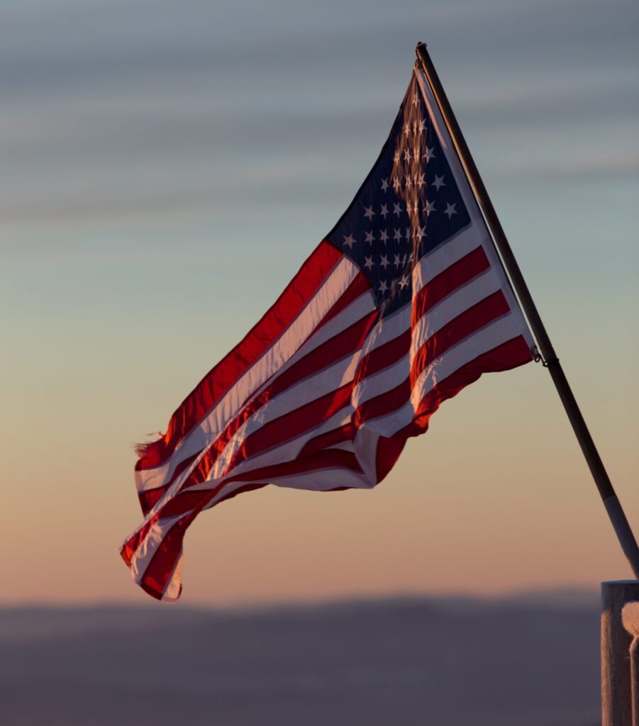 Photo of United States flag against a sunset